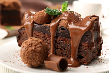 A piece of chocolate cake with mint on the table, close-up