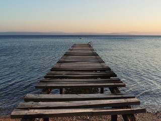 Broken old wooden pier on sunset