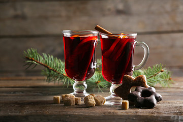 Mulled wine with cookies on wooden table