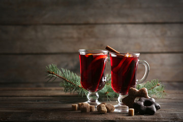 Mulled wine with cookies on wooden table
