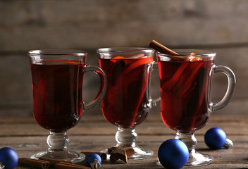 Mulled wine with blue Christmas toys on wooden table