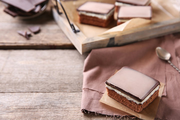 Delicious chocolate brownies on tray, on wooden background