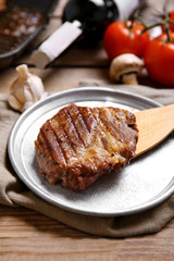 Roasted beef fillet on plate, on wooden background