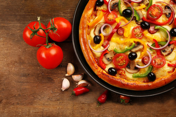 Delicious pizza with vegetables, on wooden table, close-up