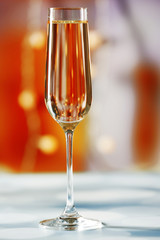 A glass of champagne on blurred lighted background