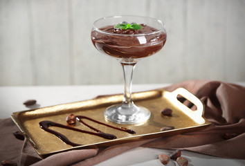 Chocolate dessert in glass on color wooden background
