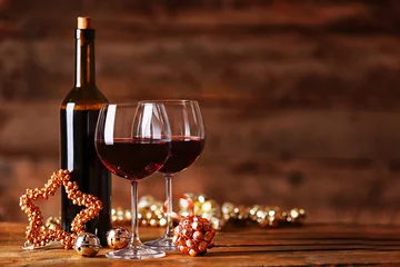 Gordijnen Red wine and Christmas ornaments on wooden table on wooden background © Africa Studio