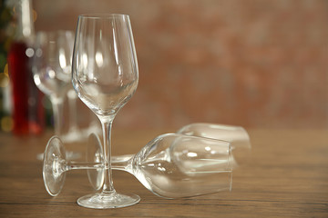Empty wine glasses with bottle on wooden table against blurred background