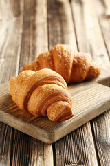 Tasty croissants on brown wooden background