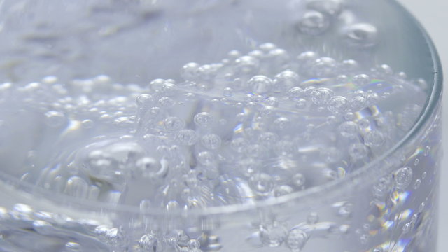 Ice cubes and soda water. Pouring soda water with ice and bubbles in the glass. Сlose-up 4K UHD.
