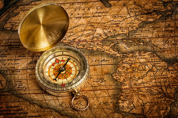 Old vintage golden compass on ancient map