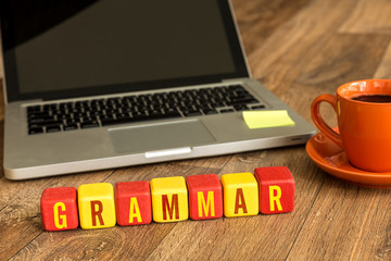 Grammar written on a wooden cube in a office desk