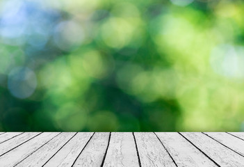 Green bokeh and sunlight and wood floor. Beauty natural backgrou