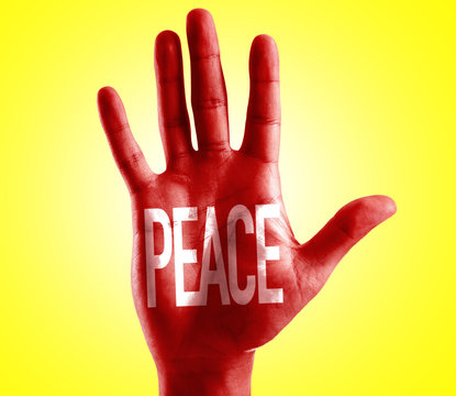 Peace written on hand with yellow background