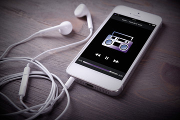 Mobile phone and earphones on wooden background