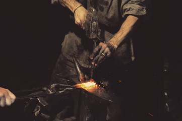 Blacksmith working metal with hammer