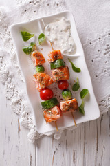 Salmon kebab with vegetables on a plate. vertical top view
