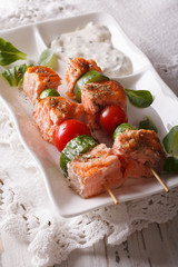 Grilled salmon on skewers  on a plate and sauce. vertical
