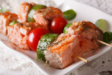 Grilled salmon on skewers macro on a plate. Horizontal
