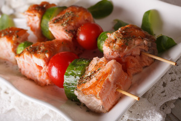 Red fish with vegetables on skewers macro on a plate. horizontal
