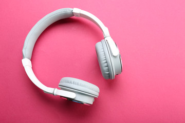 Wireless white and grey headphones on pink background