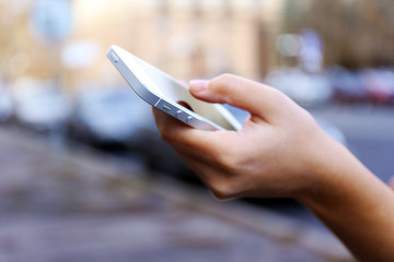 Woman holding smartphone outside