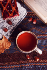 Cup of tea with autumn decor on wooden table.