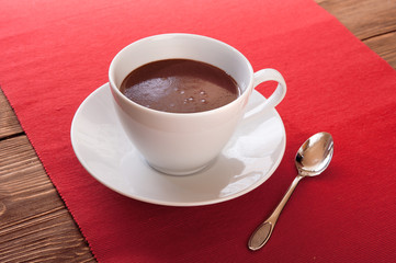 Hot chocolate in a white cup on a wooden table