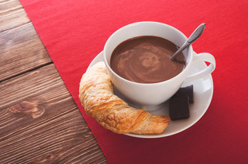 Hot chocolate in a white cup on a wooden table