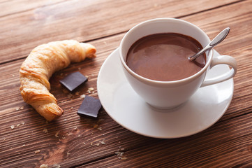 Hot chocolate in a white cup on a wooden table
