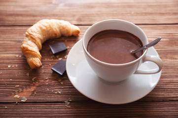 Hot chocolate in a white cup on a wooden table