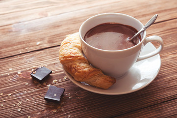 Hot chocolate in a white cup on a wooden table