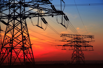 The silhouette of the evening electricity transmission pylon