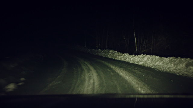 Car View of a Dark Bumpy Road at Night and During the Winter