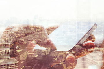 Double exposure of cityscape and smart phone, business technology concept. 