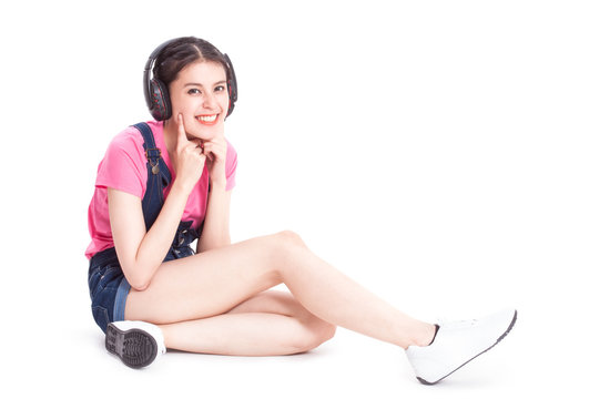 Young woman listening to music and sitting on the floor.