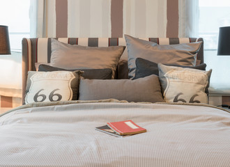 cozy bedroom interior with dark brown pillows and reading lamp o