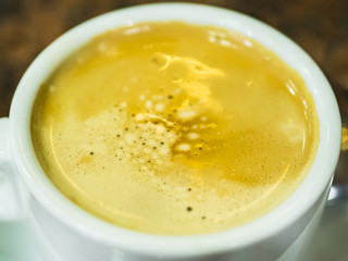 taza blanca llena de café con leche