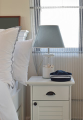 Cozy bedroom interior with reading lamp on bedside table