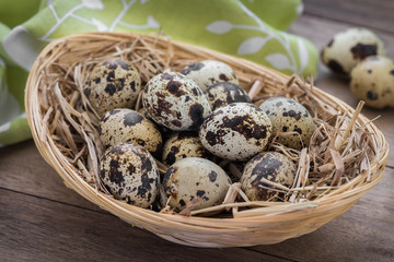 Quail eggs with straw in basket