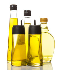 Sesame seed oil, flax seed oil, olive oil, corn oil and vegetable cooking oil in bottles over white background