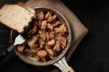 Pieces of sausage fried with onions