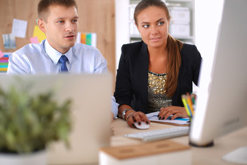Fototapeta premium Fashion designers working in studio sitting on the desk