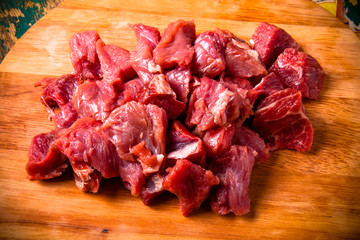 Fresh raw meat on light cutting board on an old wooden table. In