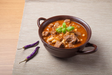 Traditional turkish meal - Kuru fasulye in a clay bowl on a ligh