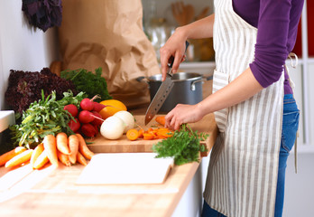Young woman cutting vegetables in the kitchen