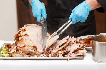 Man Carving Slices Of Roast ham 