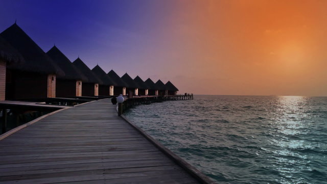 Maldives. houses on piles on water at  time sunset.
