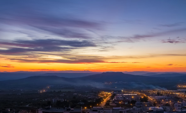 sunset scene with mountains in background and city Matera in foreground, industrial view
