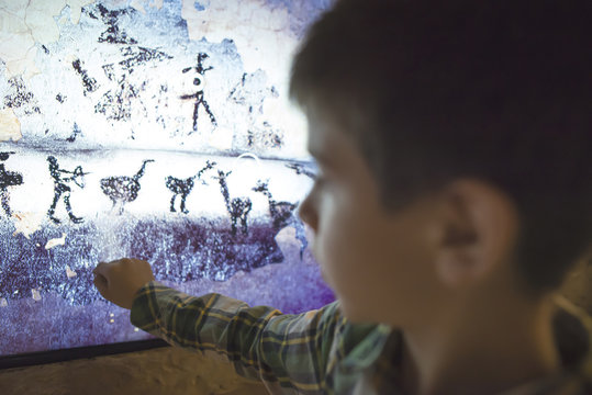 Child Looks At Aancient Mural